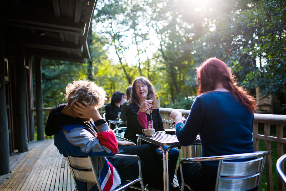 Visitors sit outside on the Castell Henllys cafe veranda