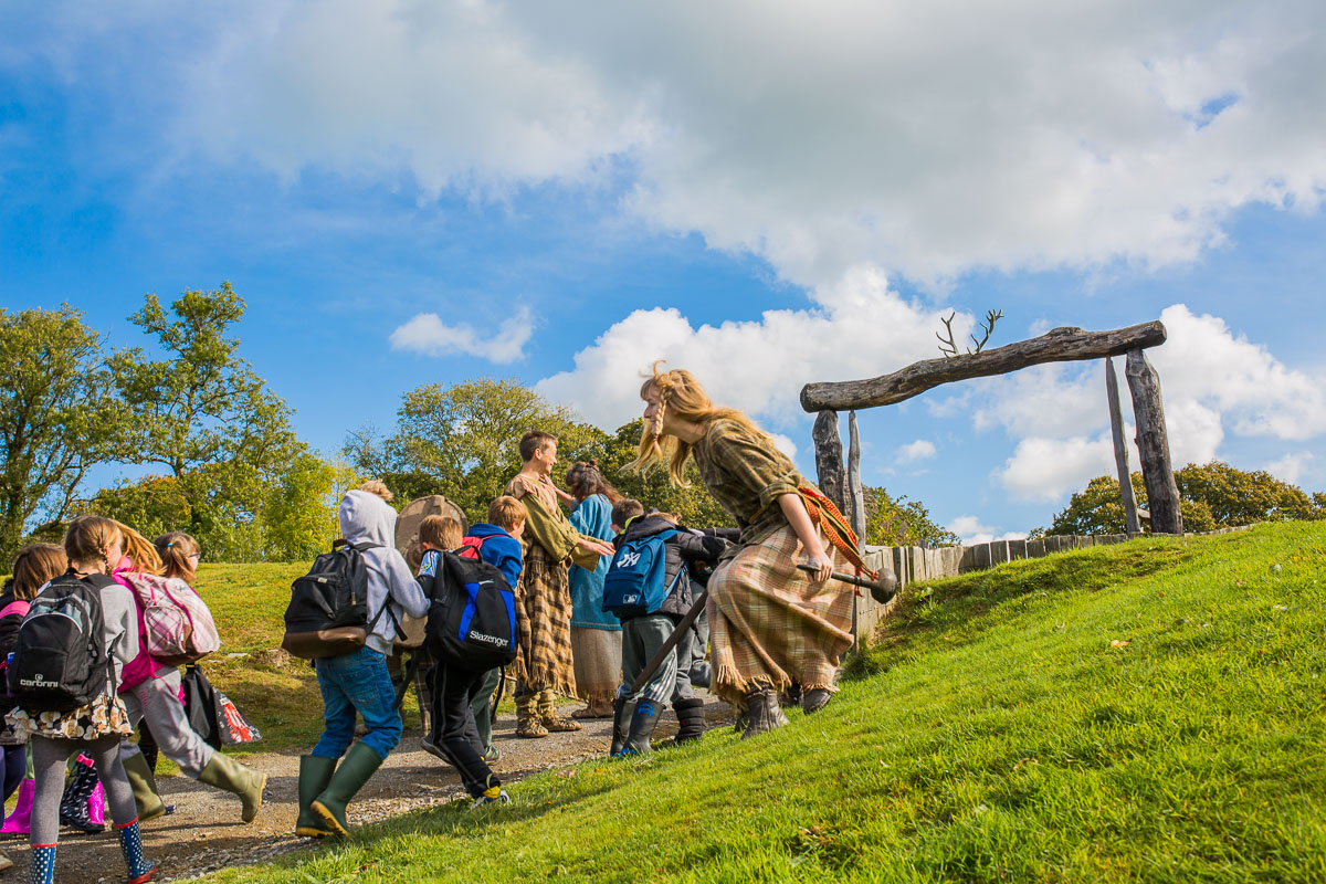 A costumed guide is running up a hill with a group of people