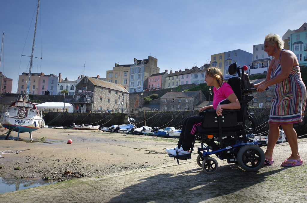 Beach wheelchair being pushed on Tenby beach
