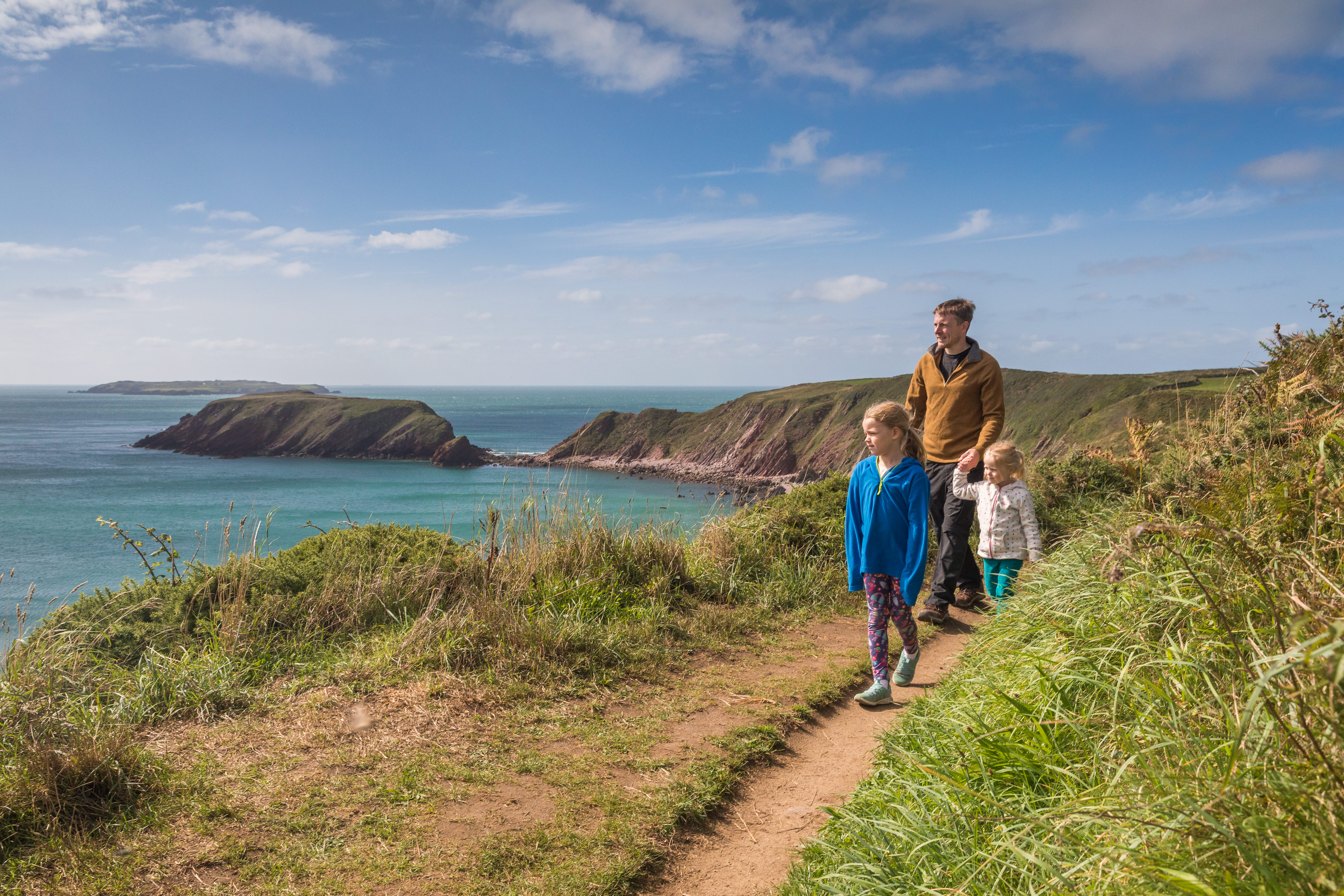 Family walking on Pembrokeshire Coast Path near Marloes