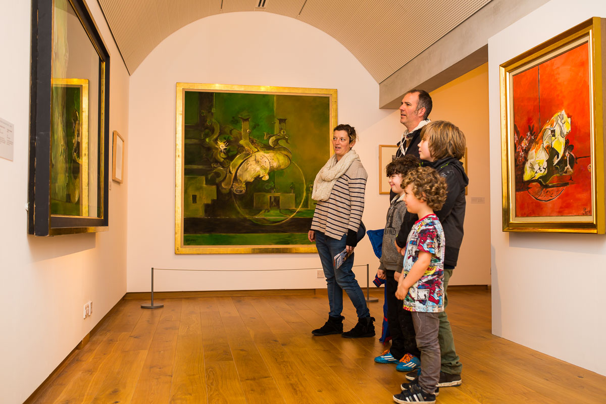 A family is viewing a Graham Sutherland painting