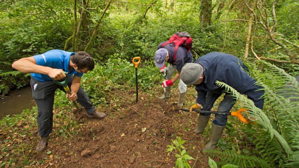 Volunteers building an otter holt with National Park Ranger Chris Taylor