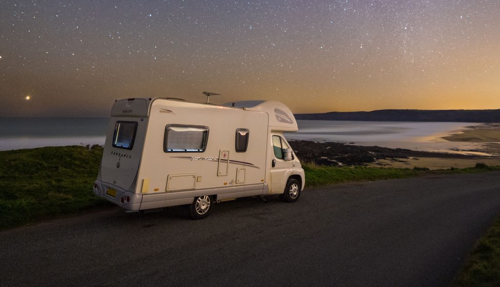 Campervan parked near coastline at dusk