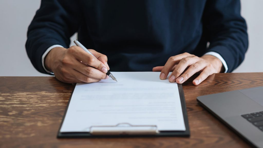 Businessman signing financial contract and hand holding pen putting signature