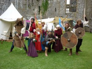 Group of people in medieval dress holding swords and shields