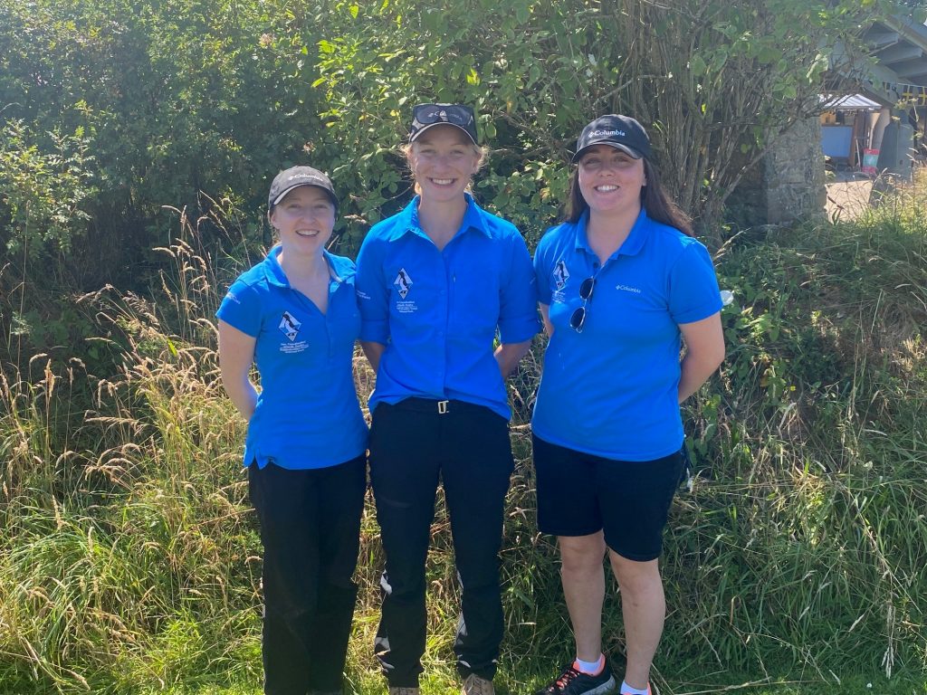 Three young Pembrokeshire Coast National Park female Summer Rangers in bright blue shirts