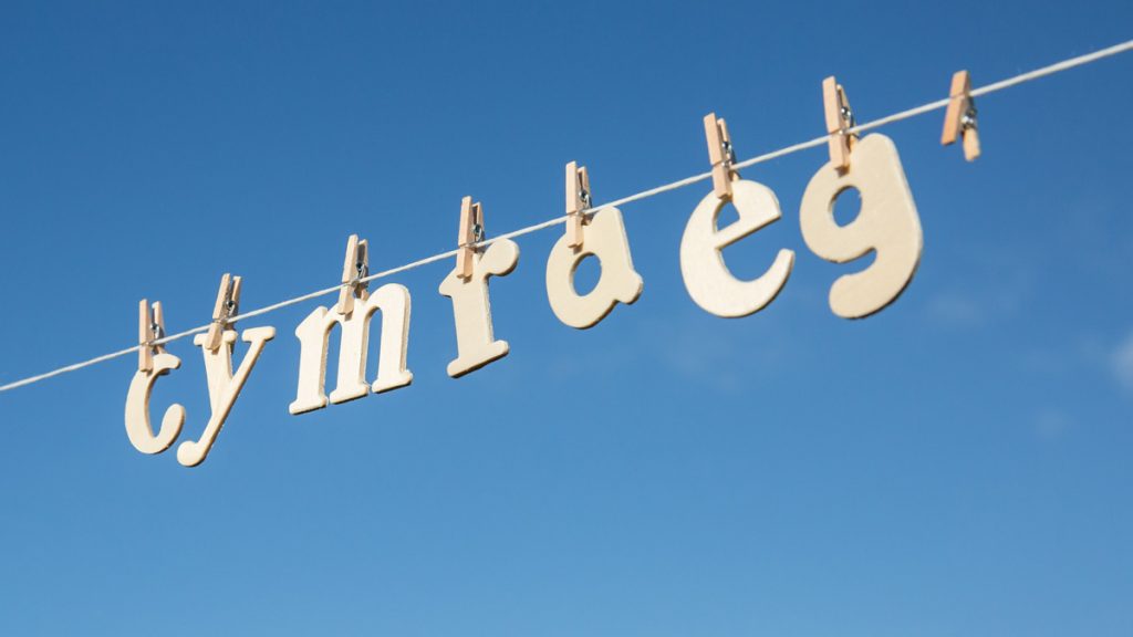 Wooden letters pegged to a washing line spelling out the word 'Cymraeg' (Welsh)