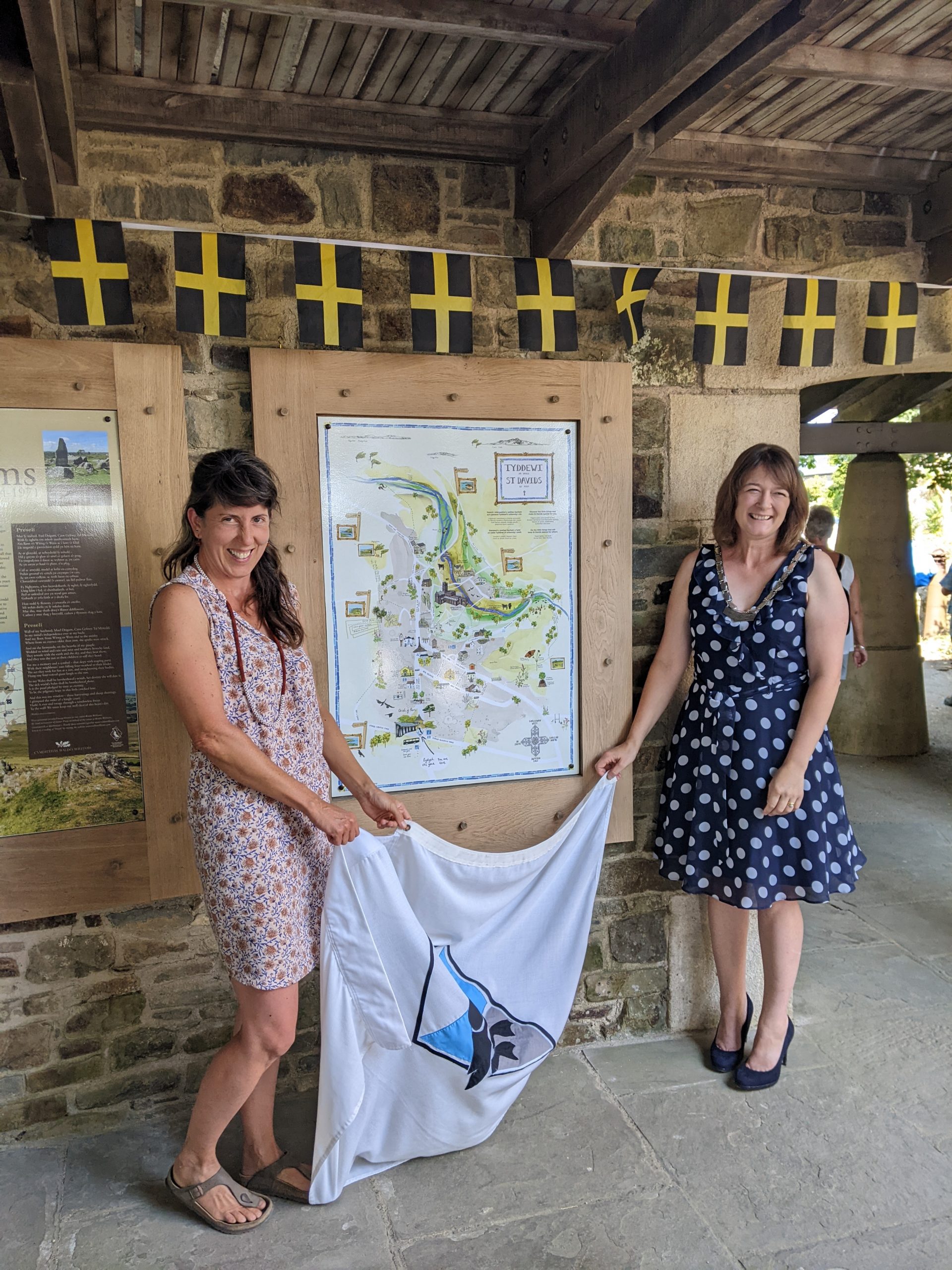 Artist Hannah Rounding and Deputy Mayor of St Davids Cllr Emma Evans unveiling a new map of St Davids outside Oriel y Parc Gallery and Visitor Centre