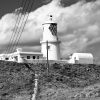 Mike Bradshaw Strumble Head Black and white photograph of a lighthouse atop a grassy hill. Location photograph is Strumble Head