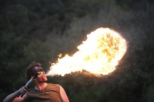 A performer breaths a ball of fire 