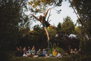 A circus performer hangs suspended with arms and legs spread apart