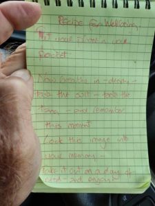 Poem written in a notebook. It reads: Recipe for wellbeing: Put your phone in our pocket. Now breathe in - deeply - taste the salt - taste the tang - and remember this moment Lock this image into your memory Take it out on a day of need - and enjoy