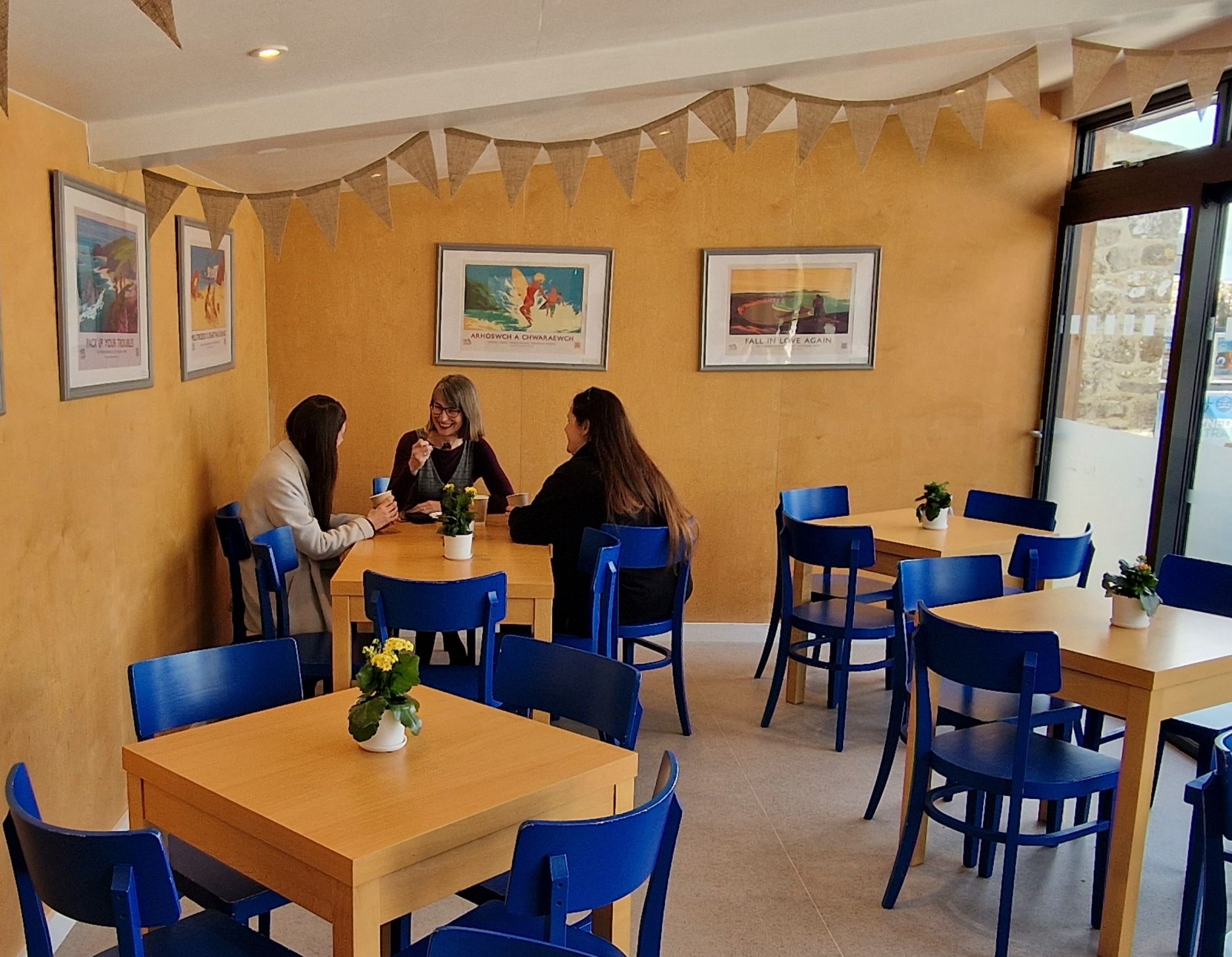 Three adults sitting around a table at Nest Tearoom.