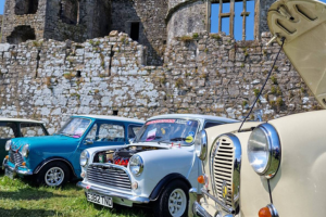 Classic cars in front of Carew Castle on a sunny day.