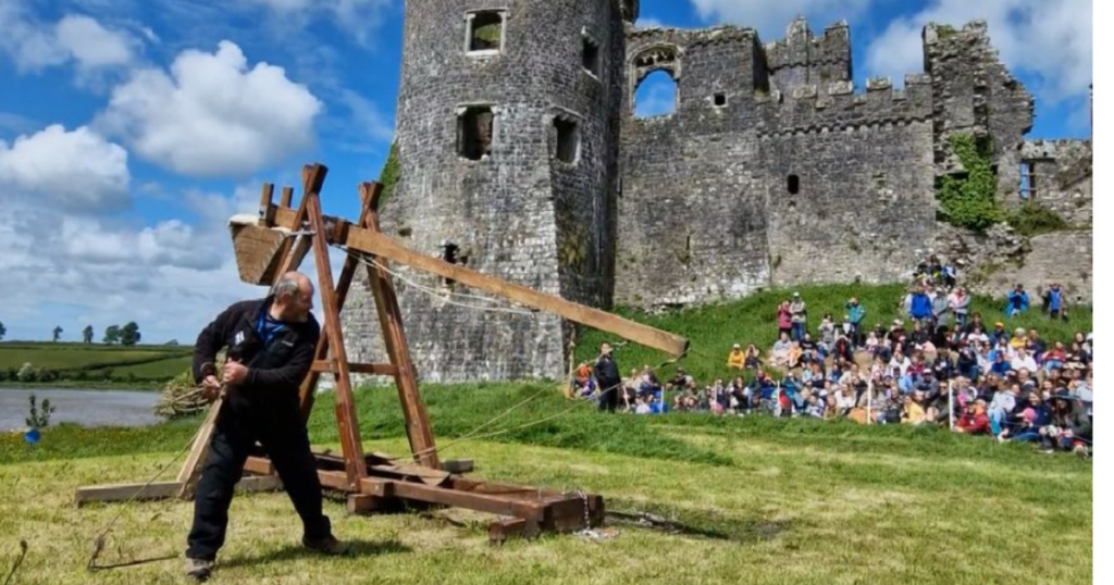 A cropped image of a trebuchet being fired outside Carew Castle