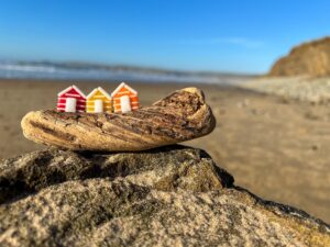 Image of glass beach huts on a piece of driftwood